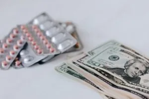 Dollar bills and pills on a table