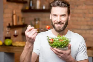Vegan man eating a salad